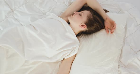 Disturbed Annoyed Young Woman Toss and Turns Lying Awake in Bed