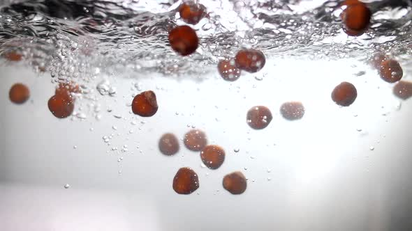 Ripe hazelnut hazelnut plunges under water in slow motion