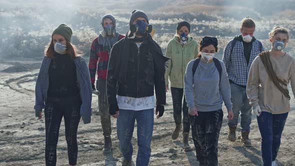 Group of young people in gas mask going through the toxic smoke in a desolate