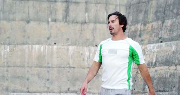 Tired sportsman standing with racket