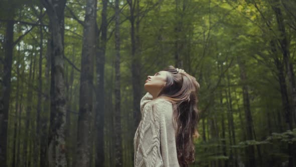 Woman looking up in forest