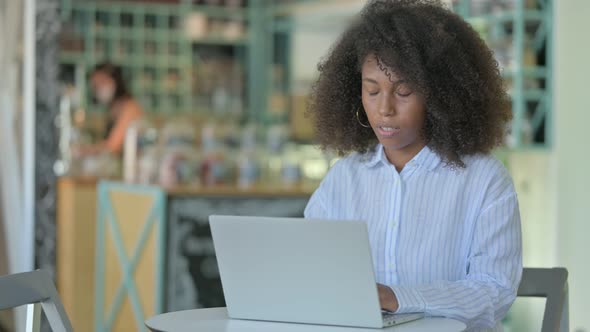 Tired African Woman with Laptop Having Neck Pain in Cafe 