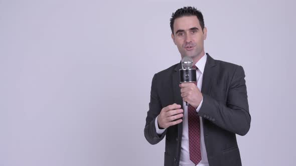 Handsome Businessman Presenting Something with Microphone
