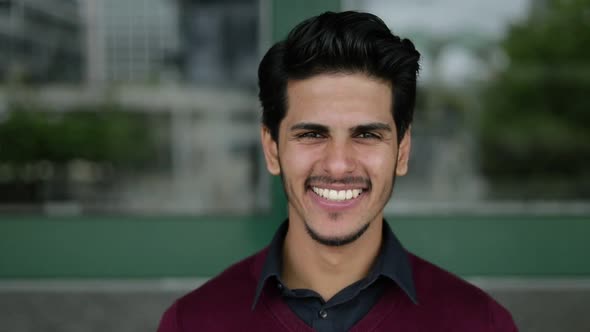 Mixed-race Man Looking at Camera, Smiling, Correcting Hair