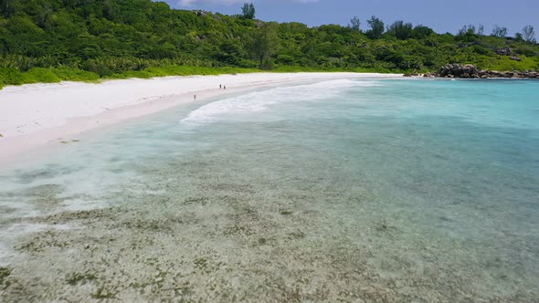 Aerial Low Altitude Fly Footage Over Tropical White Sand Beach and Turquoise Water Lagoon with Long