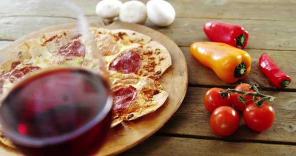 Delicious pizza with a glass of wine, vegetable and spices