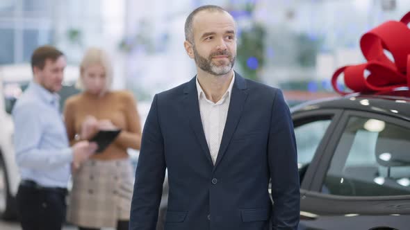 Middle Shot of Satisfied Bearded Middle Aged Man Holding Car Key Making Victory Gesture Standing in
