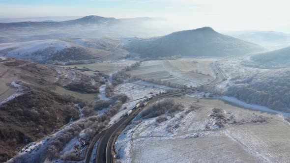 Aerial View of a Winding Road With Driving Cars in a Frosty Winter Sunny Day