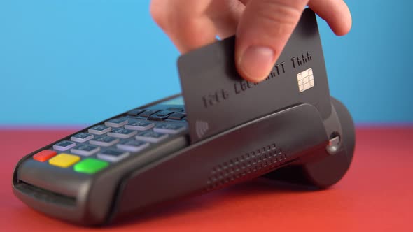 Contactless Payment By Terminal Use Black Credit Card Close Up To Pay Bill