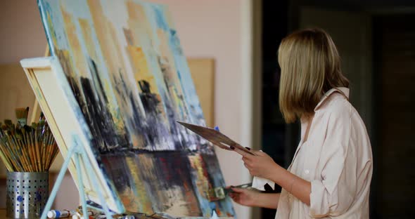 Abstract Art Painter Holding Brush and Palette in Studio