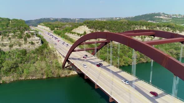 Flying above the Pennybacker Bridge in Austin, Texas flying towards hillside.