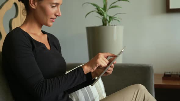 Side view of Caucasian woman using digital tablet in lobby at hospital 4k