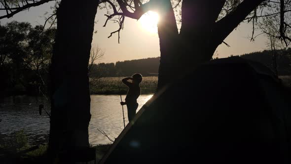 Silhouette of a Child Looking Into the Distance on the Background of the River