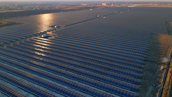 Aerial Drone View of Large Solar Panels at a Solar Farm at Bright Sunset in Early Winter