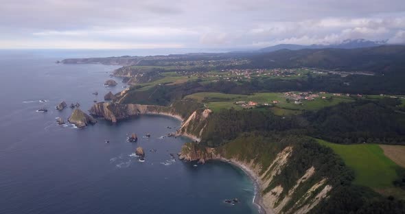 Flying above Ribadesella natural rocky cliff coastline. Asturias paradise. Spanish tourism