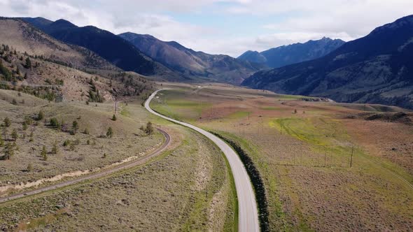 Drone revealing a car driving through mountain highway