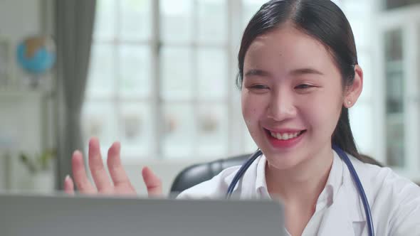 Close Up Asian Female Doctor Communicates With Patient By Video Link on Laptop Computer