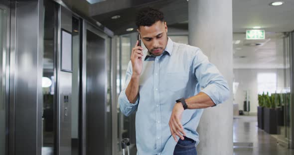 Video of biracial businessman using smartphone and checking watch