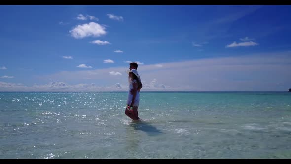 Man and lady sunbathing on tranquil lagoon beach adventure by blue sea with white sand background of