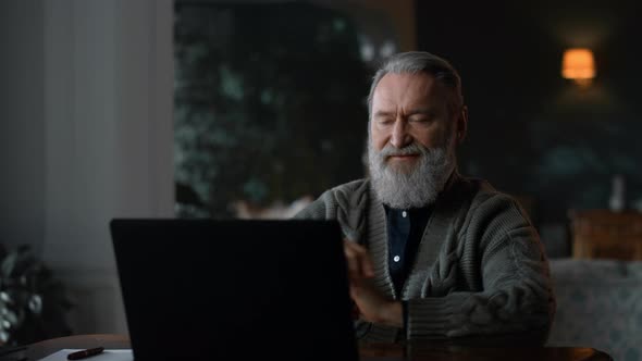 Senior Man Calling Video Online at Laptop Computer