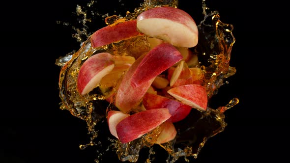 Super Slow Motion Shot of Rotating Exploded Red Apple Cuts and Splashing Juice on Black at 1000Fps