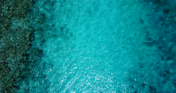 Beautiful overhead travel shot of a white sand paradise beach and aqua blue ocean background in colo