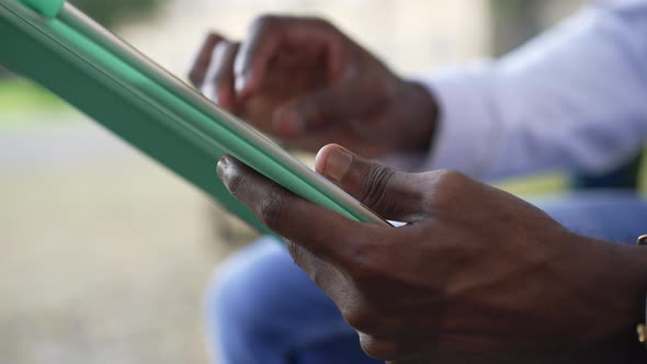 Closeup African American Male Hands with Tablet Surfing Internet Messaging Online