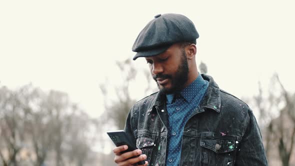 Stylish African Young Man Outside with His Smartphone