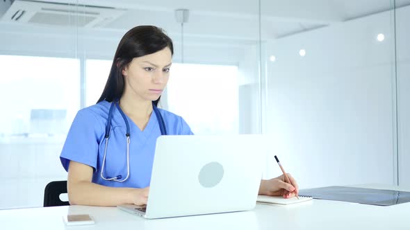 Doctor Writing Medical Reports of Patient, Sitting in Front