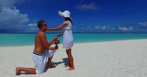 Young man and woman on honeymoon vacation live the dream on beach on clean white sand 4K background