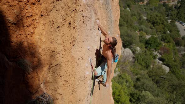 Slow Motion Top View of Strong Handsome Man Rock Climber Climbs on Vertical Cliff By Tough Route