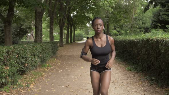 Beautiful black american athlete running in the park-slow motion