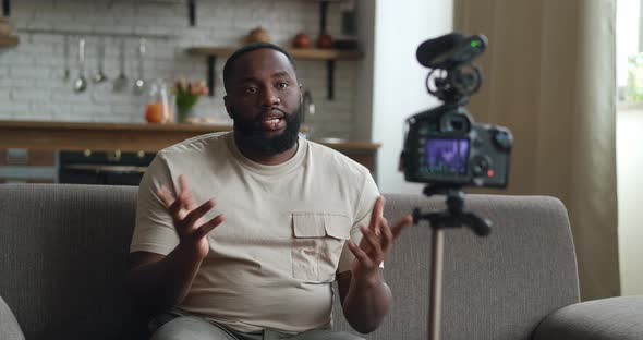 African American Man Blogger Filming Vlog Video for Internet with Professional Camera at Home