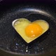 Romantic man cooking an egg with a heart for breakfast on Valentine's Day. - VideoHive Item for Sale