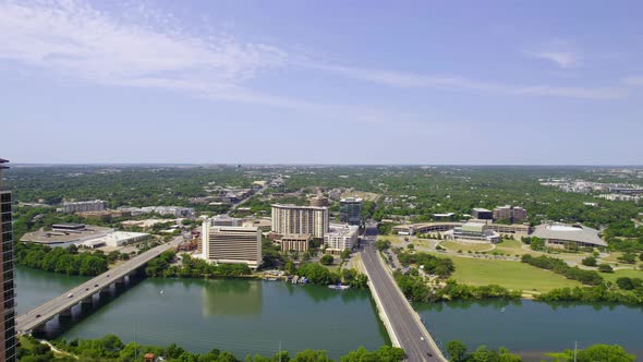 Aerial view overlooking bridges on the Colorado river in sunny Austin, USA - pan, drone shot