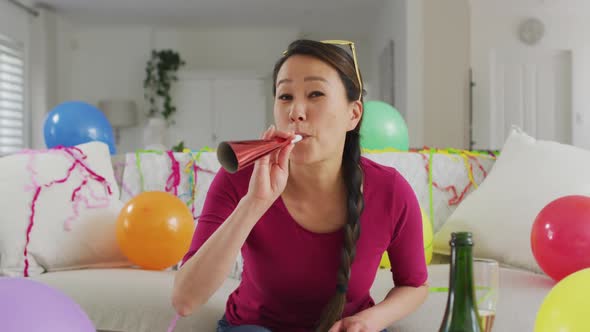 Happy asian woman with party decorations making new year's eve laptop video call