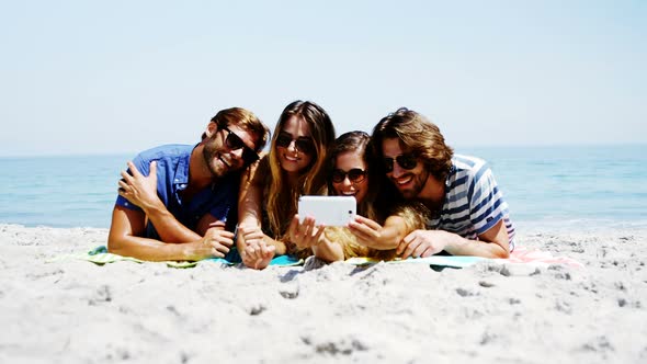 Friends taking a selfie on mobile phone at beach