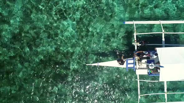 Aerial view of two people preparing to snorkeling in turquoise water.