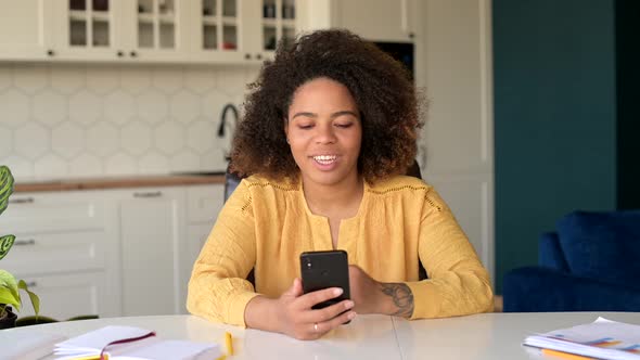 Optimistic AfricanAmerican Woman Talking By Video Call on the Smartphone