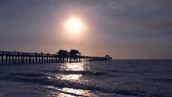 Dark Silhouette of a Pier Over the Ocean at Sunset