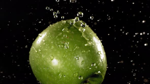 Flying of Green Apple in Black Background in Slow Motion