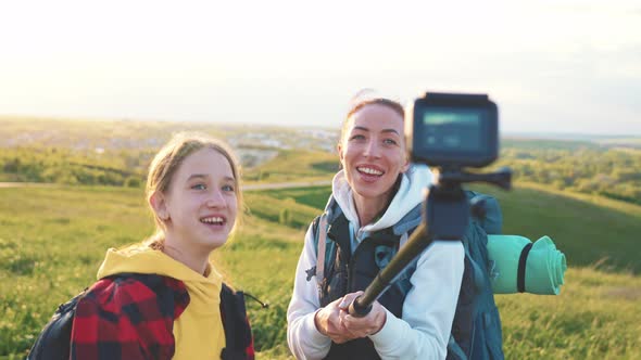 Mom and Daughter in Nature Shoot Video Blog on Camera a Selfie Stick About Tourist Trip on Mountain