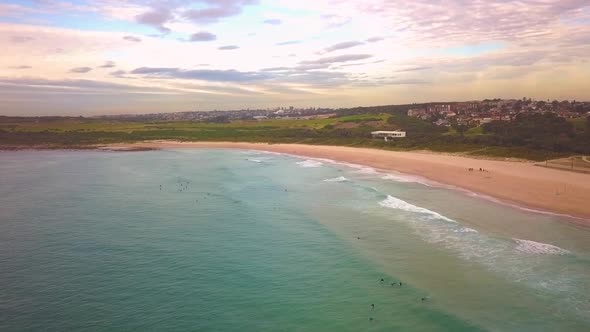 Aerial shot of surfers catching waves, surfing in winter on a windy cloudy morning, Maroubra Beach,