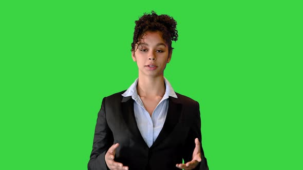 African American Woamn in a Black Jacket Talking on Camera on a Green Screen Chroma Key