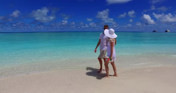 Beautiful lady and man on honeymoon vacation have fun on beach on sunny white sandy 4K background