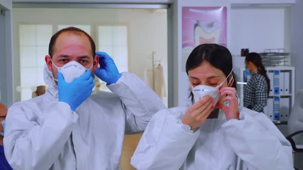 Portrait of Team Doctor in Dental Office Taking Off Protective Masks