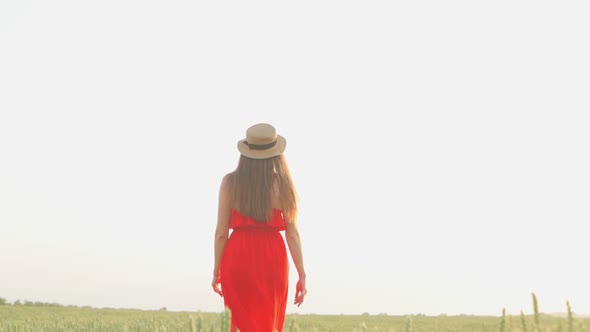 Girl in a Red Dress in a Wheat Field at Sunset