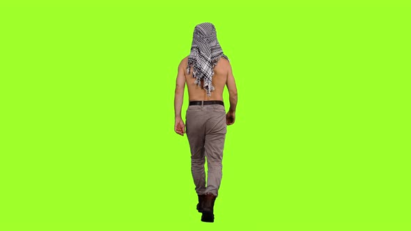 Rear View of Man with Naked Torso Walks on Green Background