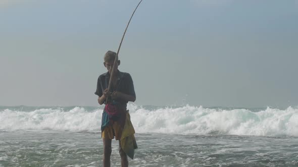 Aged Sinhalese Man with Wooden Fishing Pole at Ocean Slow