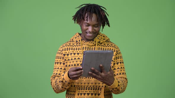 Young Happy Handsome African Man Using Digital Tablet and Thinking